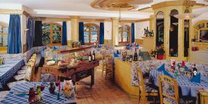 un restaurante con sofás, mesa y sillas en Hotel Waldheim Belvedere, en Bresanona