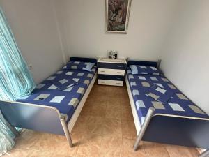 a bedroom with two beds and a nightstand and a bed sidx sidx sidx sidx at Cozy Room For Rent Near Beach in Vlorë