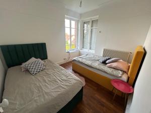 a bedroom with two beds and a window at douces nuits in Vierzon