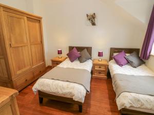 2 Betten in einem Zimmer mit lila Kissen in der Unterkunft Lavender Cottage in Warwick