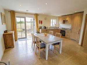 eine Küche mit Tisch und Stühlen in einem Zimmer in der Unterkunft Daisy Cottage in Warwick