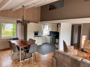 a kitchen and dining room with a table and a couch at L'Orée du Bois in Trois-Ponts