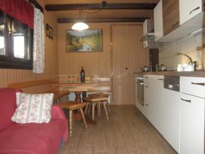 a kitchen with a couch and a table in a room at Holiday Home Čumar in Cerkno
