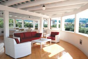 a porch with couches and a table and chairs at Ganimede Hotel in Sperlonga
