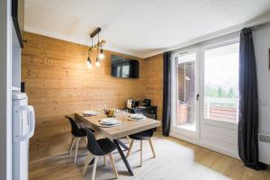 ein Esszimmer mit Tisch und Stühlen und einem Fenster in der Unterkunft Le Berger - Apt dans résidence 4 étoiles au pied des pistes in Huez