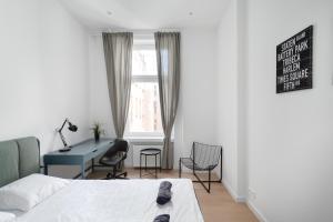 a bedroom with a bed and a desk and a window at Central Apartments Lodz - 13 People - 3 Bedroom Apartment - City Center -GN56 in Łódź