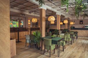 a restaurant with green tables and chairs and lights at Hotel Tazz - River Front Oasis Collection in Bihać