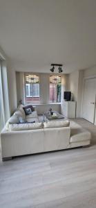 a large white couch in a living room at Der Springbrunnen in Egmond aan Zee