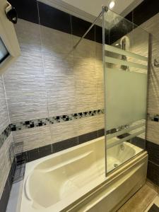 une salle de bain avec baignoire et douche en verre dans l'établissement Madinaty - 2 BedroomBeauty, à Madinaty 21 autres photos