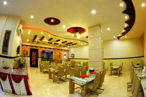 a dining room with tables and chairs in a restaurant at Bahla Hotel Apartments in Bahlāʼ