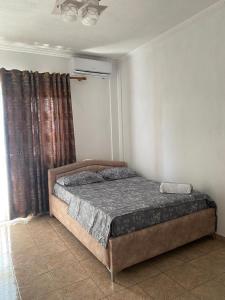 ドゥラスにあるAjsi Apartmentsの窓のある部屋にベッドがある寝室