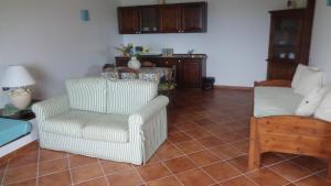 een woonkamer met een stoel en een bank bij Villino Caddu in San Teodoro +60 foto's