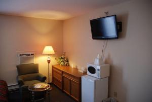 a living room with a tv and a lamp at Commons Inn in Halifax