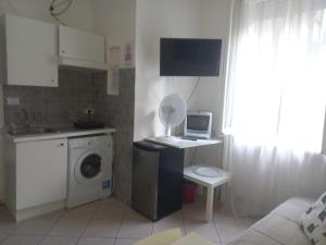 una piccola cucina con lavatrice e forno a microonde di MICHELANGELO 26 Monolocale a Milano Altre 11 foto