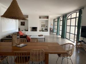 ein Wohnzimmer mit einem Holztisch und Stühlen in der Unterkunft Calme et confort dans un écrin de verdure in Montferrier-sur-Lez