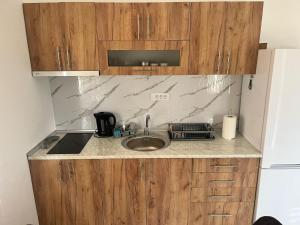 a kitchen with a sink and wooden cabinets at Madavajo in Petrovac na Mlavi