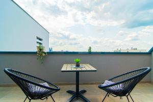 two chairs and a table on a balcony with a table at Flexible SelfCheckIns 93 - Zagreb - Garage - Balcony - Bedroom in Zagreb