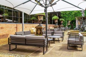 a group of chairs and tables with an umbrella at The Queen at Chester Hotel, BW Premier Collection in Chester