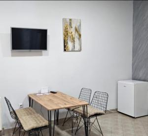 a dining room with a table and chairs and a tv at Apartman SPLENDID in Kladovo