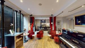 a living room with red chairs and a piano at Best Western Hotel Opéra Drouot in Paris