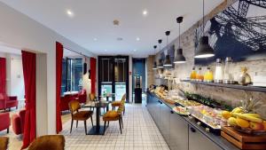 a restaurant with a long counter with food on it at Best Western Hotel Opéra Drouot in Paris