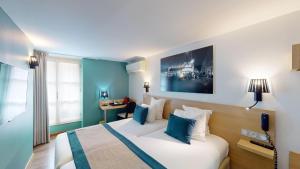a hotel room with a bed with blue walls at Best Western Hotel Opéra Drouot in Paris