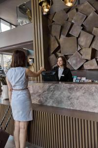 a woman standing at a counter in front of a woman at Avantgarde Urban Sisli in Istanbul