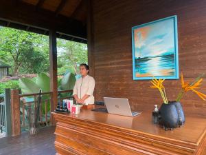 a man standing at a desk with a laptop at The Postcard Hideaway, Netravali Wildlife Sanctuary, South Goa in Vichondrem +119 photos
