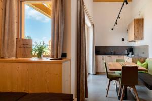 a kitchen and dining room with a table and a window at Moserhof Wohnung Salbei in Meltina