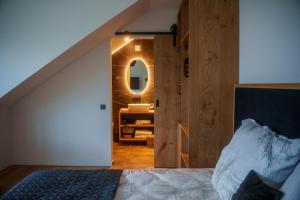 a bedroom with a bed and a bathroom with a mirror at Hotel Frost in Maribor