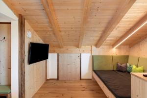 a room with a couch and a flat screen tv at Moserhof Wohnung Salbei in Meltina