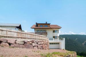 a house on top of a rock wall at Moserhof Wohnung Salbei in Meltina