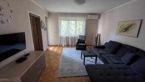 un soggiorno con un divano e una TV di Stan Daleka Obala a Mostar