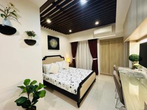 a bedroom with a bed and a dining room at Inspiria Cozy Condo in Cabaguio