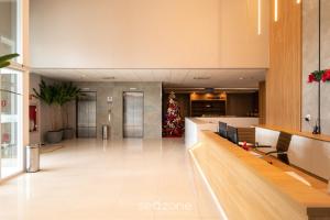 an office lobby with a christmas tree in the distance at Studios aconchegantes no Setor Marista BLS in Goiânia