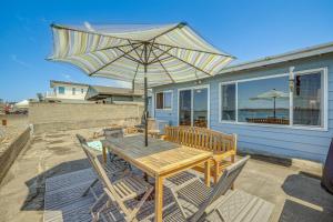 - une table et des chaises en bois avec un parasol sur la terrasse dans l'établissement Oceanfront Cottage with Patio and Views in Birch Bay!, à Blaine