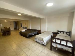 a hotel room with two beds and a table and chairs at Departamento Belgrano 11 in Salta