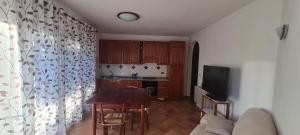 a living room with a table and a kitchen at Casa vacanza 70 mq in Valledoria