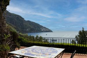 a table on a balcony with a view of the ocean at Villa Anna Maria Positano in Positano
