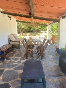 a patio with a table and chairs on a stone patio at Casa do Monte - Esperança in Esperança