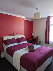 a bedroom with a large bed with red walls at Railway Inn in Culham
