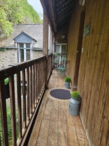 a porch of a wooden house with a table and chairs at Escapade sur le port de Dinan in Dinan