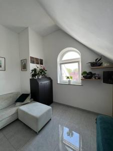 a living room with a couch and a window at Jurgis Guest house in Kaunas
