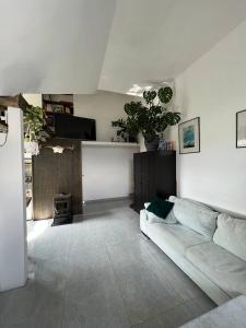 a living room with a white couch and a tv at Jurgis Guest house in Kaunas