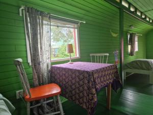 a green room with a table and a window at Cirkus Hostel Holken in Inkoo +74 photos