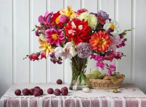 a vase of flowers sitting on a table with fruit at Hotel Atlantis Amsterdam in Amsterdam