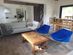 a living room with a couch and two blue chairs at Maison familiale in Le Teich