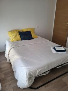 a large white bed with yellow pillows in a room at Maison familiale in Le Teich +6 photos