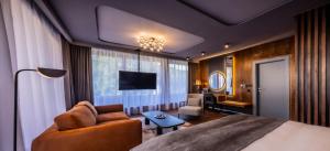 a bedroom with a bed and a living room at Apeiro City Avant-garde Hotel in Sarajevo