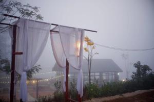 a foggy yard with white curtains in front of a house at Fuang Dao Mountain Resort in Muang Fuang +34 photos